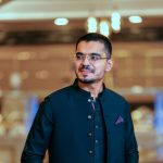 Confident man in traditional Pakistani kurta with smartphone. Fashionable indoor setting.
